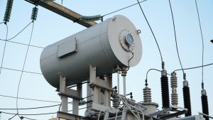 Electrical equipment. Electric substation. High voltage transformer against the blue sky.